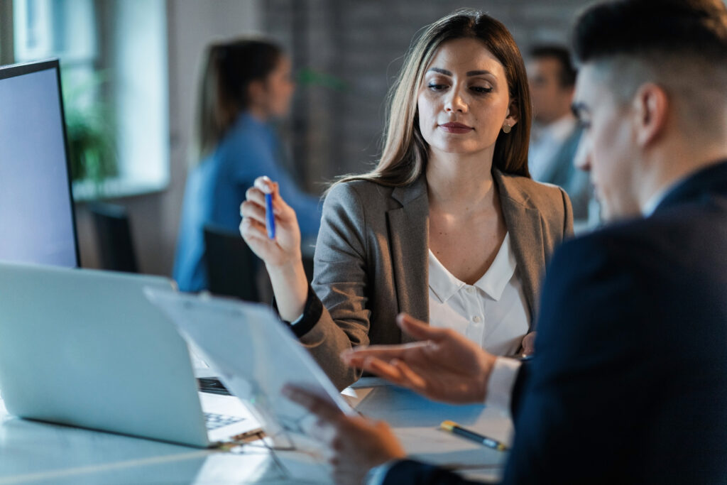 Young businesswoman and her coworker analyzing business reports in the office.